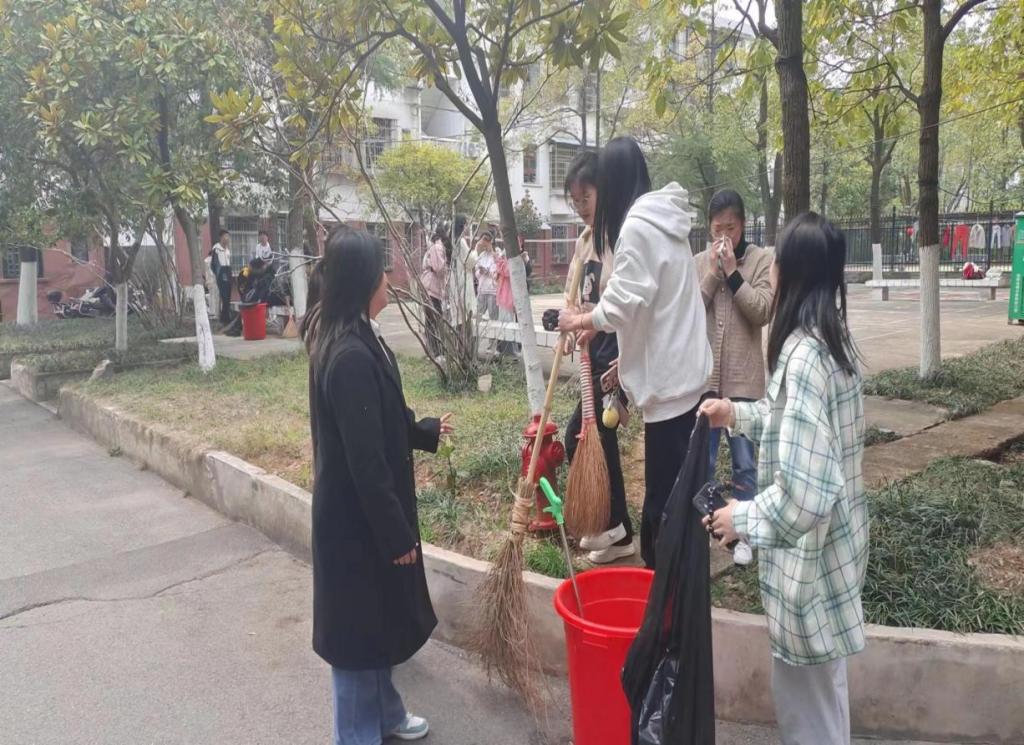 同学们把落叶装入垃圾袋